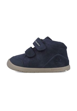 Botines de ante azul marino con dos tiras de velcro, puntera reforzada y suela de goma beige flexible. Logo de la marca en el lateral.