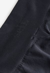 Prim-plan cu material negru cu dungi, cu text subtil în relief sau brodat, evidențiind textura și detaliile țesăturii.