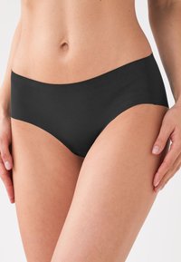 Zwarte hipster briefs met een naadloos ontwerp en een gladde textuur, voorzien van een lage taille en minimale bedekking.