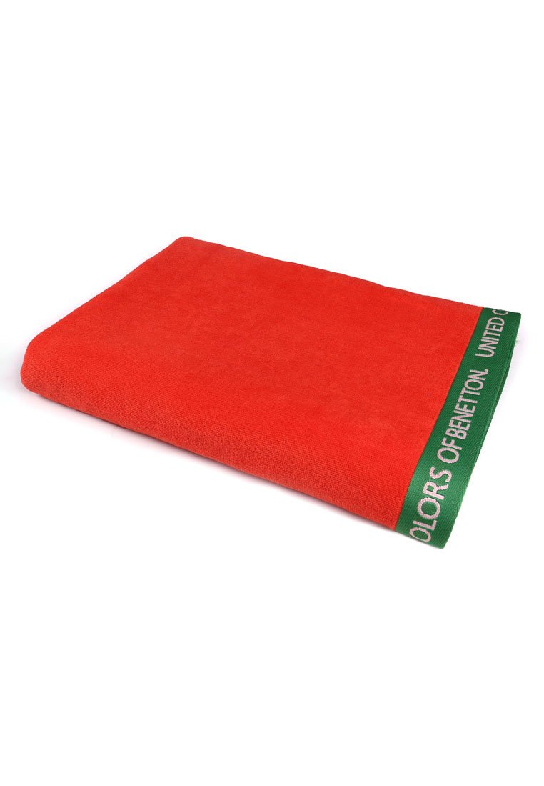 Serviette rouge en tissu éponge doux avec un texte "UNITED COLORS OF BENETTON" en blanc sur une bordure verte à une extrémité.