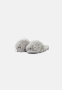 Faux fur slippers in light gray with a plush upper, wide band design, and flat rubber sole, featuring textured fur and a simple shape.