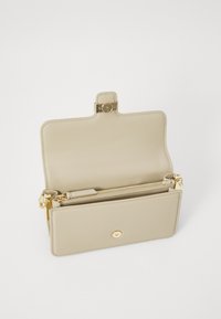 Clutch in pelle beige con chiusura a scatto dorata, tasca interna con zip e superficie liscia. Aperta, mostra i compartimenti di organizzazione all'interno.