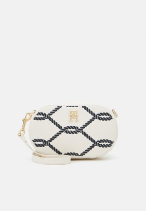 Kleine witte ovale crossbodytas met marineblauw touwpatroon en gouden gesp met riem op witte achtergrond.