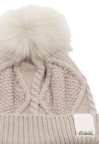 Cappellino a maglia beige con un grande e soffice pompon crema sulla sommità. Presenta motivi testurizzati ed un'etichetta del marchio visibile sul risvolto.