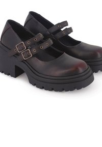 Zapatos Mary Jane de cuero negro con dobles hebillas, suelas de plataforma negra gruesa y diseño de puntera redonda. Suela de goma texturizada.