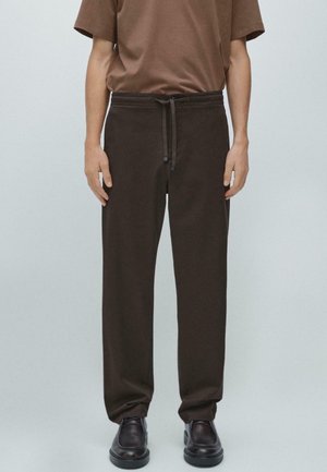 Bruine, ontspannen pasvorm broek gemaakt van zachte stof, met een elastische tailleband met trekkoord en taps toelopende pijpen. Soepele textuur.