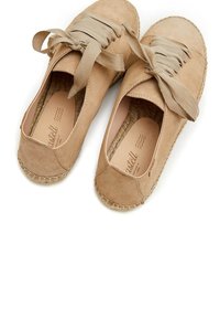 Espadrilles de ante en tono marrón con anchos cordones de tela, puntera redondeada y suela de yute trenzado con detalles de costura a lo largo del borde. Textura suave.