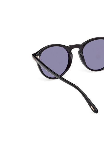 Ochelari de soare negri cu rame rotunde, lentile violet și o finisare lustruită, elegantă. Brațele au un accent subtil de aur.