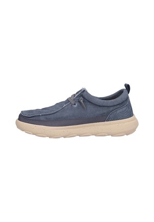 Zapato casual de corte bajo de color azul marino sin cordones con suela moteada beige y detalle de cordones elásticos, diseñado para comodidad y uso diario.