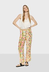 Mönstrade byxor i livliga färger (rosa, grön, gul, blå) med vida ben, utrustade med en dekorativ midja och tryckt mönster.