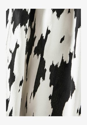 Tissu noir et blanc présentant un motif abstrait audacieux avec une finition texturée. Le design évoque un effet de coup de pinceau, créant un intérêt visuel.