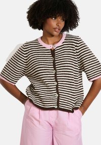 Brūns un balts svītrots īsu piedurkņu kardigans ar rozā apkakli, ar apaļām pogām pa priekšu un brīvu piegriezumu.