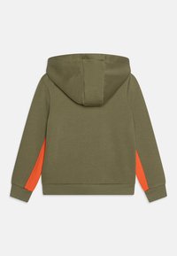 Sweat à capuche vert olive avec des accents latéraux orange, fabriqué en tissu doux. Il présente une coupe standard et des poignets et un ourlet en côtes.