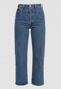 Jeans de mezclilla azul de cintura alta con corte recto, que cuentan con trabillas para cinturón, bolsillos frontales y un cierre de botón. Diseño clásico de cinco bolsillos.