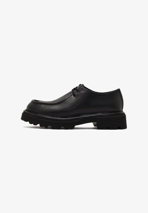 Black leather shoe with round toe, lace-up design, and a thick, textured sole. The upper features a smooth finish and minimal stitching.