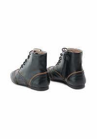 Botas de cuero negras hasta el tobillo con costuras marrones, puntera redondeada, cordones en la parte delantera y cremallera lateral. Textura suave y diseño minimalista.