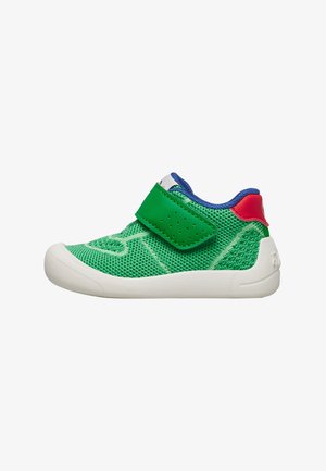 Baskets vertes pour tout-petit avec semelle blanche, doublure bleue, languette rouge au talon et bride velcro verte, dessus en tricot, vue latérale.