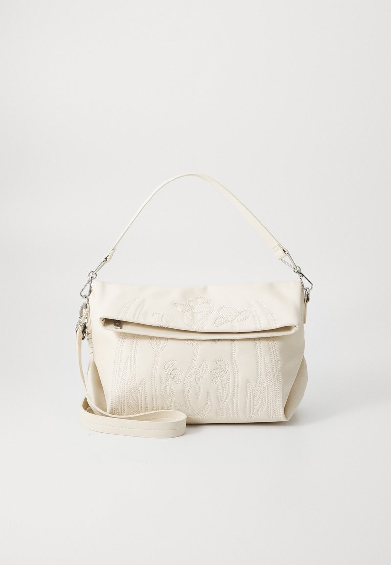 Sac à main crème avec poignée supérieure et bandoulière amovible, présentant une broderie florale subtile sur le rabat avant.