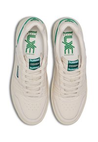 Weiße Ledersneaker mit grünen Akzenten. Zu den Merkmalen gehören eine perforierte Zehenbox, eine Schnürung auf der Vorderseite und eine Logo-Prägung an Zunge und Seite.