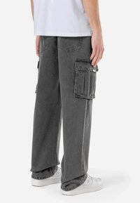 Cargo shorts in vervaagde grijze denim, met meerdere zijzakken, een relaxte pasvorm en gestikte details. Draag ze met witte sneakers.