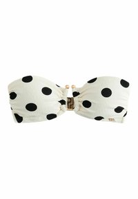 Top de bikini bandeau alb cu buline mari negre și cataramă decorativă aurie în centrul frontal.