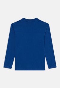 Langermet skjorte i ensfarget blå bomull. Har klassisk crew neck, myk tekstur og rett kant. Ingen synlige designmønstre eller detaljer.