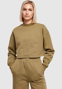 Crop sweatshirts van een khaki katoenmix, voorzien van een hoge halslijn en verlaagde schouders, gecombineerd met bijpassende joggers. Zachte, gestructureerde afwerking.