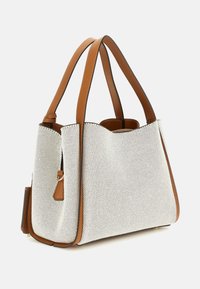 White perforated tote bag with brown leather accents and handles. Features a structured shape and stitched detailing at the edges.