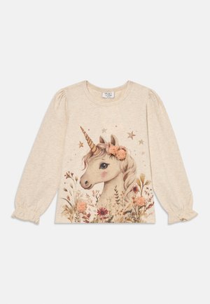 Lys beige langermet skjorte med et enhjørning-grafikk av blomster og stjerner. Mykt stoff, rynkede ermer og rund halsutskjæring.