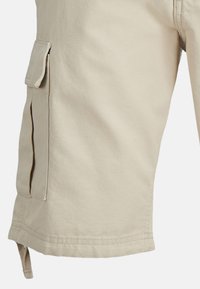 Shorts en tissu beige avec une poche cargo latérale munie d'un rabat et d'une boucle en tissu suspendue à l'ourlet.