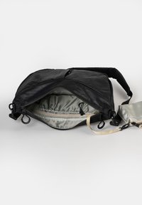 Borsa a tracolla nera con esterno liscio, fodera argento, tasca interna con zip e tracolla regolabile. Presenta attacchi a gancio e una forma strutturata.