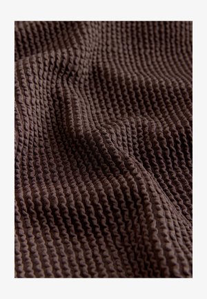 Braunes strukturiertes Gewebe mit einem gerippten Muster, das Falten aufweist, welche das gewebte Design sowie die weiche, angenehme Textur hervorheben.