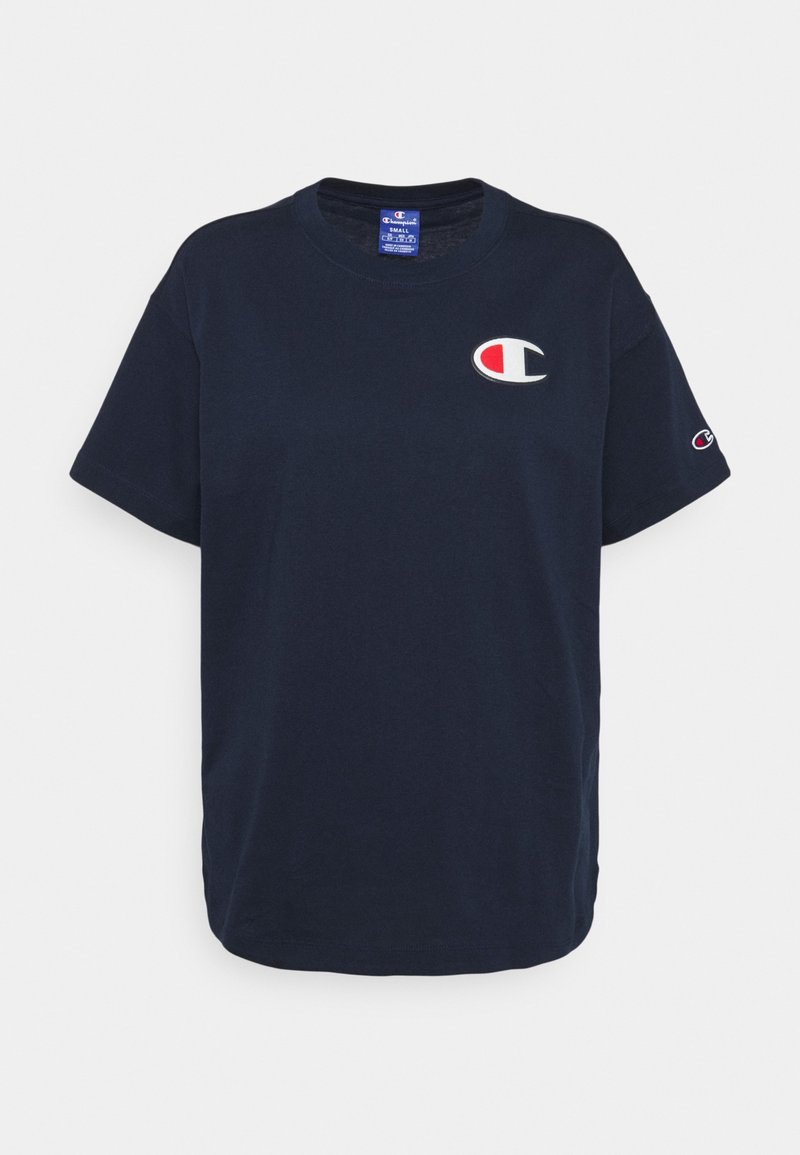 Tummansininen puuvillapaita, jossa on lyhyet hihat, pyöreä kaula-aukko ja brodeerattu logo punaisella, valkoisella ja sinisellä vasemmassa rinnassa ja hihassa.