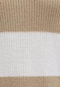 Gestrickter Stoff mit abwechselnden horizontalen Streifen in Beige und Weiß. Die Textur ist glatt mit sichtbaren Strickmaschen.