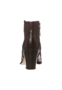 Botín de cuero marrón con tacón ajustado, cremallera lateral y costuras reforzadas. Textura suave con un diseño elegante y ajustado.
