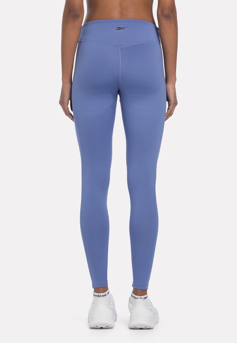 Leggings azules de cintura alta hechos de material elástico, con una textura suave y detalles de costura sutiles en la parte posterior.