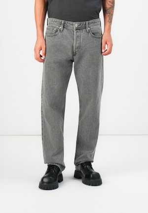 Men's grey denim jeans, straight fit, mid-rise, five-pocket design, textured finish, paired with black chunky lace-up shoes.