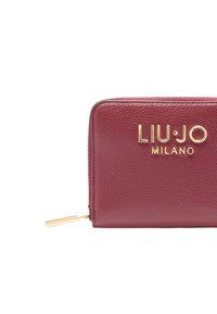 Portafoglio in pelle marrone con esterno testurizzato, logo dorato "LIU·JO MILANO" e chiusura a zip con cursore in metallo dorato.