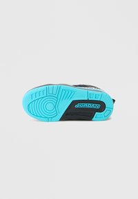 Talpa de pantof sport neagră cu o bază din cauciuc turcoaz strălucitor, cu modele de profil detaliate și un logo proeminent "JORDAN".