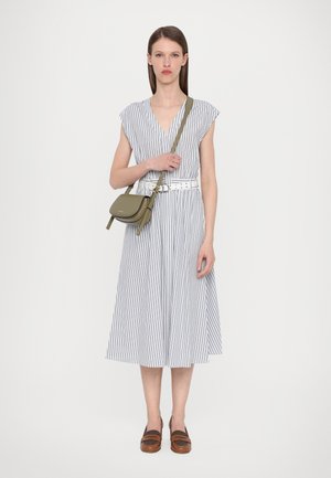 Pruhované šaty s krátkymi rukávmi a hlbokým V-výstrihom, so zúženým pásom a sukňou v A-línie. Biela opasok a olivová crossbody taška. Hnedé slip-on topánky.