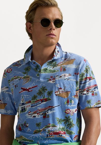 Korteblaused, lichtblauwe polo shirt met een tropische print van boten, vliegtuigen en palmbomen; heeft een knoopsluiting kraag en een borstzak.