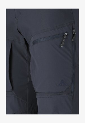 Nærbillede af mørkegrå cargobukser med lynlåslommer og detaljeret syning på lår- og knæområderne.