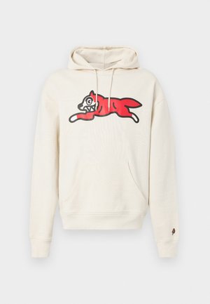 Kreemikollane kapuutsiga pusa, millel on keskel suur punase koera graafika, musta kontuuriga ja detailse näoga, ees tasku.