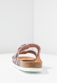 Różowe sandały w leoparda z korkową wkładką, białą gumową podeszwą i regulowanym klamrą. Otwarty design z wieloma wycięciami.