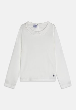 Weißes Langarmshirt mit rundem Kragen, aus weichem Material gefertigt, mit einem kleinen Logo-Akzent am Saum und Knopfverschluss im Rücken.