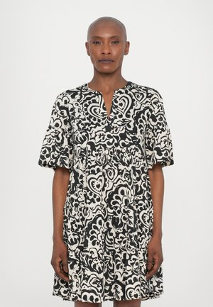 Vestido con estampado en blanco y negro, con escote en V, mangas cortas y falda acampanada. Hecho de un tejido ligero con una textura fluida.