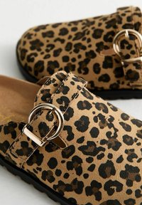 Hausschuh im Leopardenmuster mit weichem Wildleder-Obermaterial, runder Schnallenakzent und schwarzer Gummisohle für Grip und Komfort.