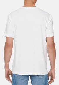 Weißes Kurzarm-T-Shirt mit klassischem Rundhalsausschnitt. Weicher Baumwollstoff, gerader Saum und umgeschlagene Ärmel. Einfaches, minimalistisches Design.