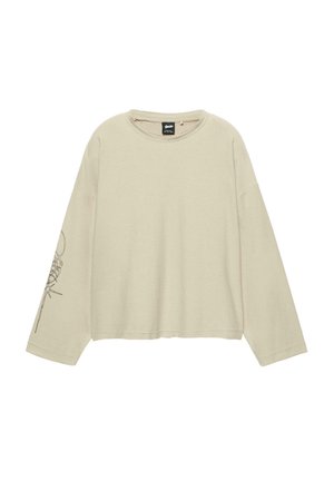 Roomkleurige top met lange mouwen, ronde halslijn, verlaagde schouders en een botanische grafische afbeelding op de linkermouw.