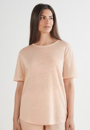 Licht perzikkleurig t-shirt met korte mouwen en een ronde hals, gemaakt van zachte, lichte stof, met een subtiele textuur en een relaxte pasvorm.